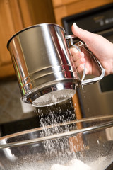 sifting flour into mixing bowl