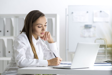 Concentrated businesswoman taking notes