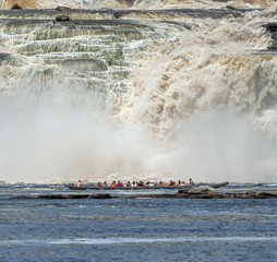 Fototapeta premium The powerful falls and tourists boat in the lagoon of the Canaima national park - Venezuela, South America