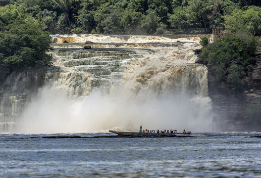Powerful falls and tourists boat in the lagoon of Canaima national park - Venezuela, Latin America