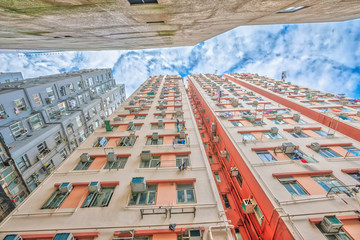 Fototapeta premium Perspective view of tall crowded residential buildings on Nathan Road, in a popular area, Tsim Sha Tsui, Kwoloon, Hong Kong.