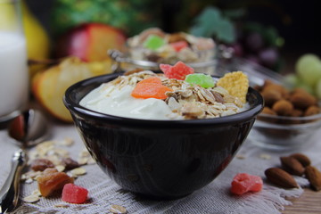 домашний йогурт и мюсли с кусочками сушеных фруктов и миндалем.полезный завтрак