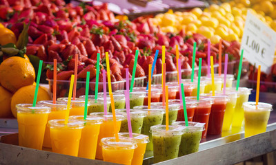 Variety of colorful, fruity drinks on ice at market