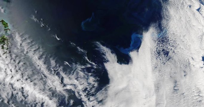 High-altitude overflight aerial of a phytoplankton bloom in the Tasman Sea, Australia. Clip loops and is reversible. Elements of this image furnished by USGS/NASA Landsat