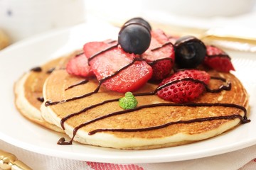 Homemade Fluffy Sour cream pancakes topped with fresh strawberries and blueberries