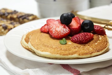 Homemade Fluffy Sour cream pancakes topped with fresh strawberries and blueberries
