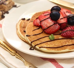 Homemade Fluffy Sour cream pancakes topped with fresh strawberries and blueberries