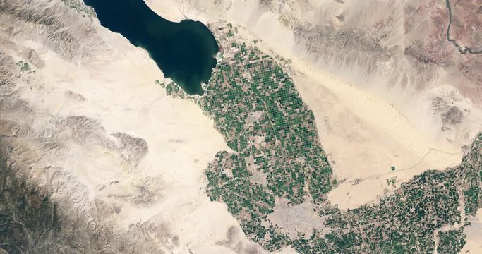 High-altitude overflight aerial of irrigated desert farmland near southern California's Salton Sea. Clip loops and is reversible. Elements of this image furnished by USGS/NASA Landsat