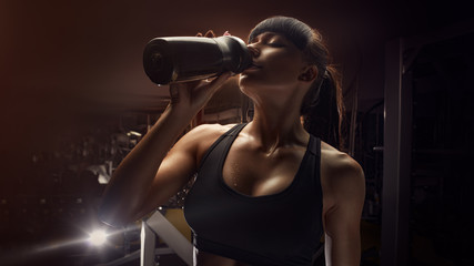 Fitness woman drinking water from bottle