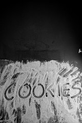 Word cookies written in flour on table