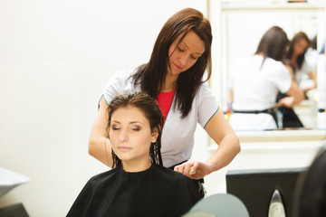 Woman getting hair cut in a beauty salon
