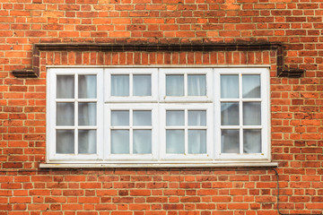 Fototapeta na wymiar Red brick wall with white window