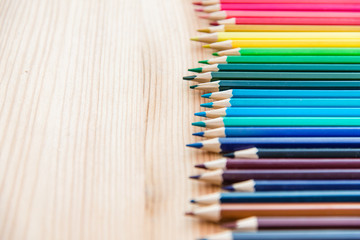 Colorful pencils on a wooden background