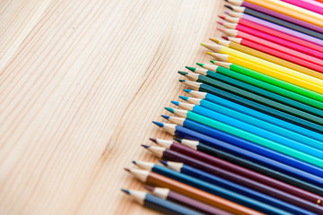 Colorful pencils on a wooden background