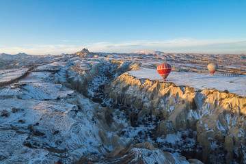 Hot air balloons fly over Cappadocia in winter, Goreme, Turkey.