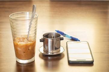 Vietnamese ice coffee with condensed milk, cafe sua da on a wood