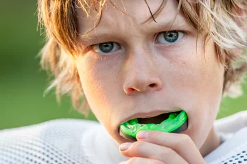 Foto op Canvas Boy putting in his mouth guard © soupstock