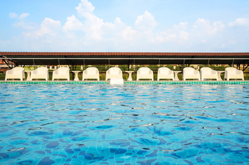 Relax white chairs by swimming poolside