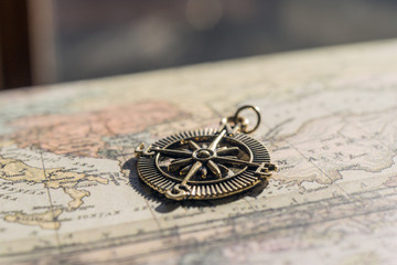 Fototapeta na wymiar Antique golden compass on a vintage map, travel background