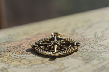 Fototapeta na wymiar Closeup of vintage compass lying on an old world map