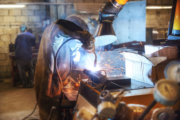 Working welder welds parts factory