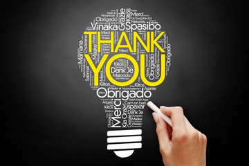 Hand writing Thank You Word Cloud bulb in many languages on blackboard, presentation background