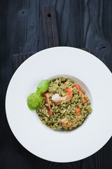 Above view of spinach and tiger shrimps risotto in a white plate