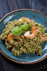 Close-up of italian risotto with spinach and tiger shrimps