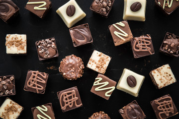 Delicious chocolate candies, truffles on the black background.