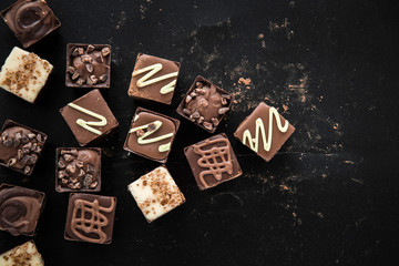 Delicious chocolate candies, truffles on the black background.