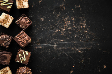 Delicious chocolate candies, truffles on the black background.