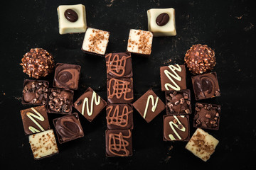 Delicious chocolate candies, truffles like a butterfly on the black background.