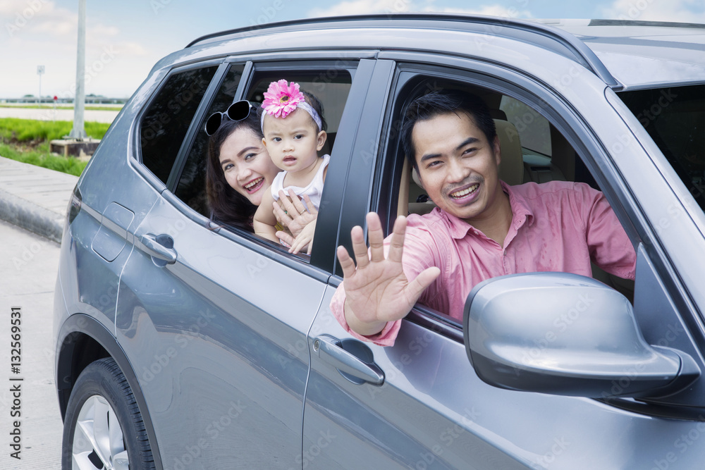 Wall mural asian family looking out window in the car