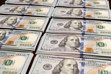 Rows of stacks of dollars on table