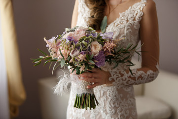 Wedding bouquet, beautiful bride in stylish wedding dress holding bouquet of fresh flowers at...