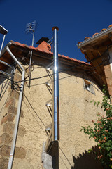 chimenea metálica en la fachada de una casa © uzkiland