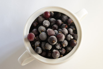 Frozen berries, black currants, in a porcelain dish. view from above. macro