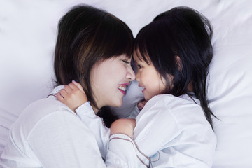 Fototapeta na wymiar Beautiful mother and daughter lying on bed