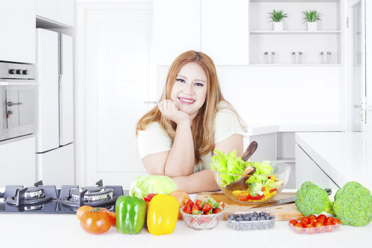 Blonde woman with vegetables in kitchen