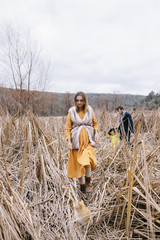 pregnant woman and a man with a girl are walking in the reeds