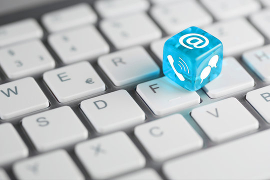 Blau T&uuml;rkis farbener / blauer t&uuml;rkiser W&uuml;rfel mit Email, Telefon und Chat zur Kontaktaufnahme auf Tastatur