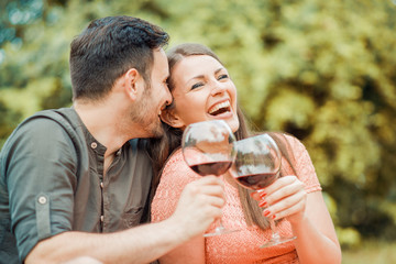 Cute young couple drinking wine on a picnic