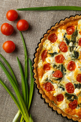 Vegetarian homemade pie, Quiche with tomatoes, spinach and feta cheese.