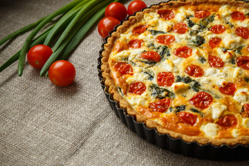 Vegetarian homemade pie, Quiche with tomatoes, spinach and feta cheese.