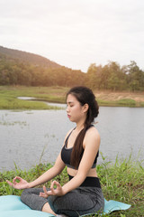Fototapeta na wymiar young woman meditates while practicing yoga outdoor in park, re