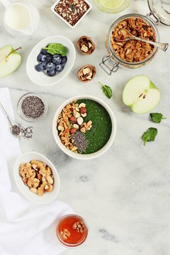 Breakfast set with granola, green smoothie and various of topping. Healthy eating and super foods concept.