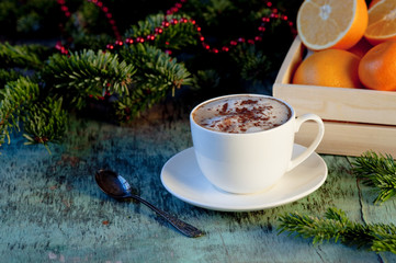 A cup of coffee on a wooden background. Coffee cappuccino with Christmas decorations and fir branches on the old wooden background. Cocoa Cappuccino Coffee Cup of coffee Wooden background
