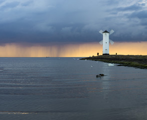 storm passing over the lighthouse at sunset