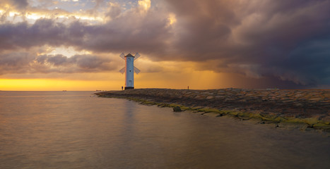 storm passing over the lighthouse at sunset