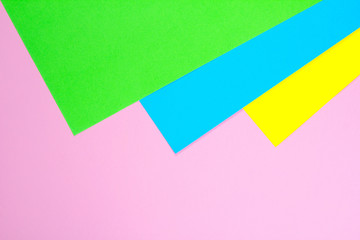 Material design yellow, blue, pink and green paper background. Photo.